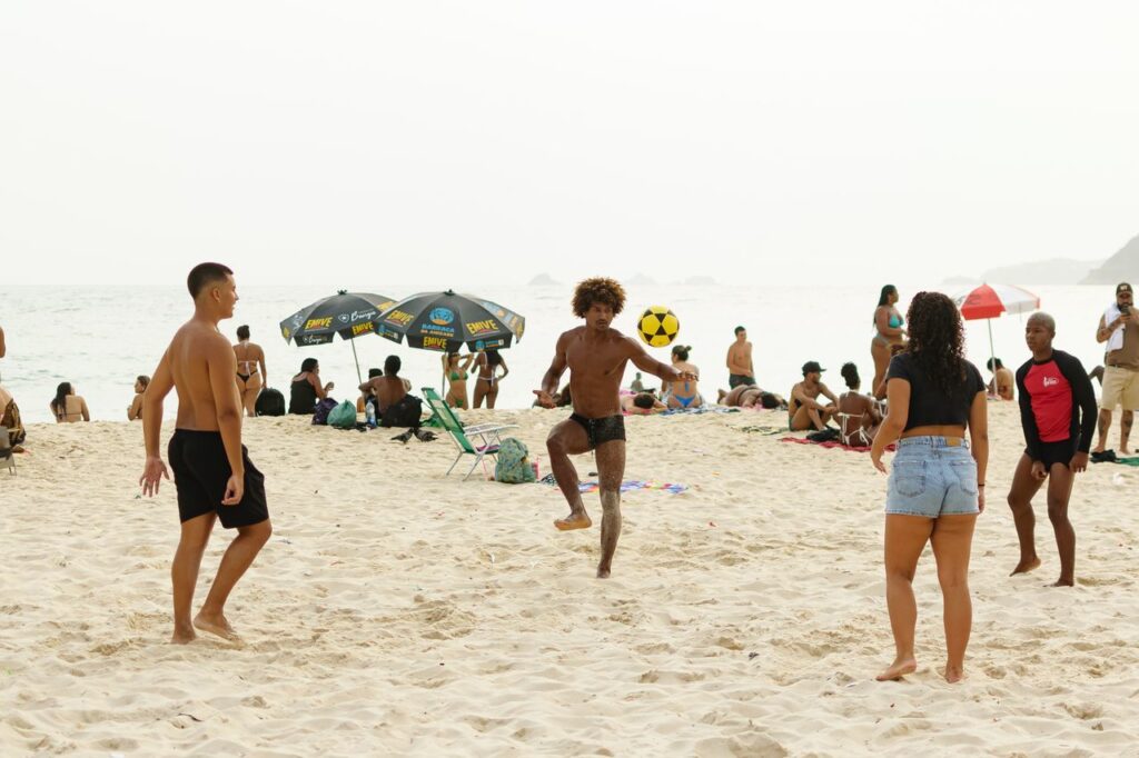 https://www.pexels.com/de-de/foto/beachvolleyballspiel-auf-dem-sand-von-rio-de-janeiro-28847731/ Menschen entspannen am Strand, genießen die Sonne und das Meer, einige spielen im Sand oder schwimmen im Wasser