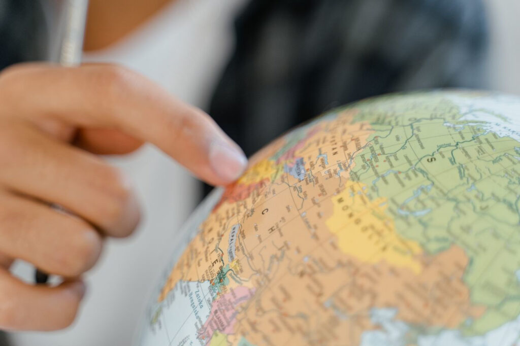 https://www.pexels.com/de-de/foto/hand-globus-objekt-selektiven-fokus-8472960/ Eine Hand zeigt mit dem Finger auf einem Globus.